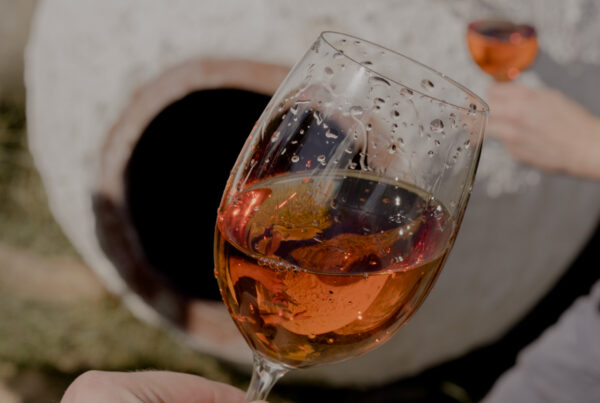 Ein Glas Orange Wein vor einer Amphore